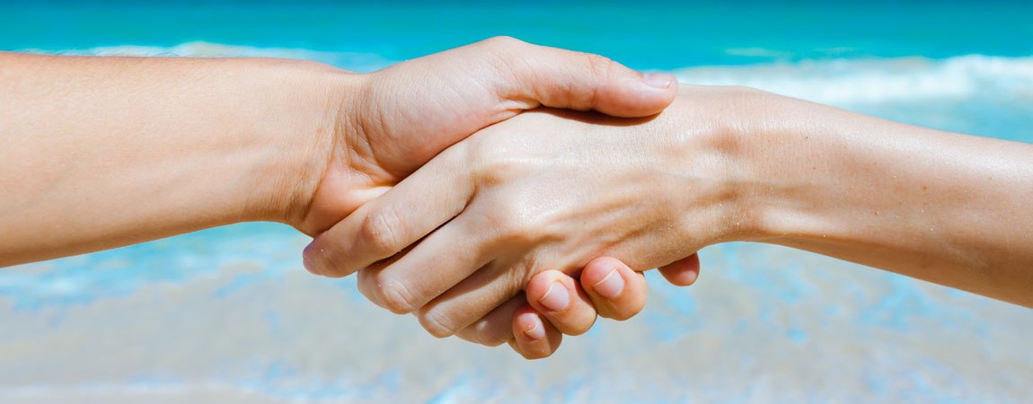 Hände schütteln sich am Strand